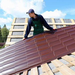 red metal roof panel installation on prepared roof